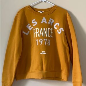 Mustard yellow crew neck sweatshirt with graphics